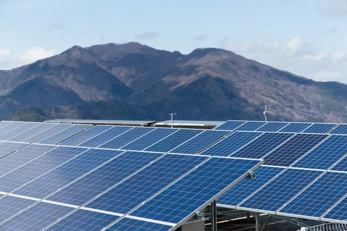 ground mount solar panels in front of a mountain